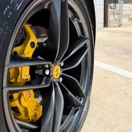 Ferrari yellow caliper behind coated wheel