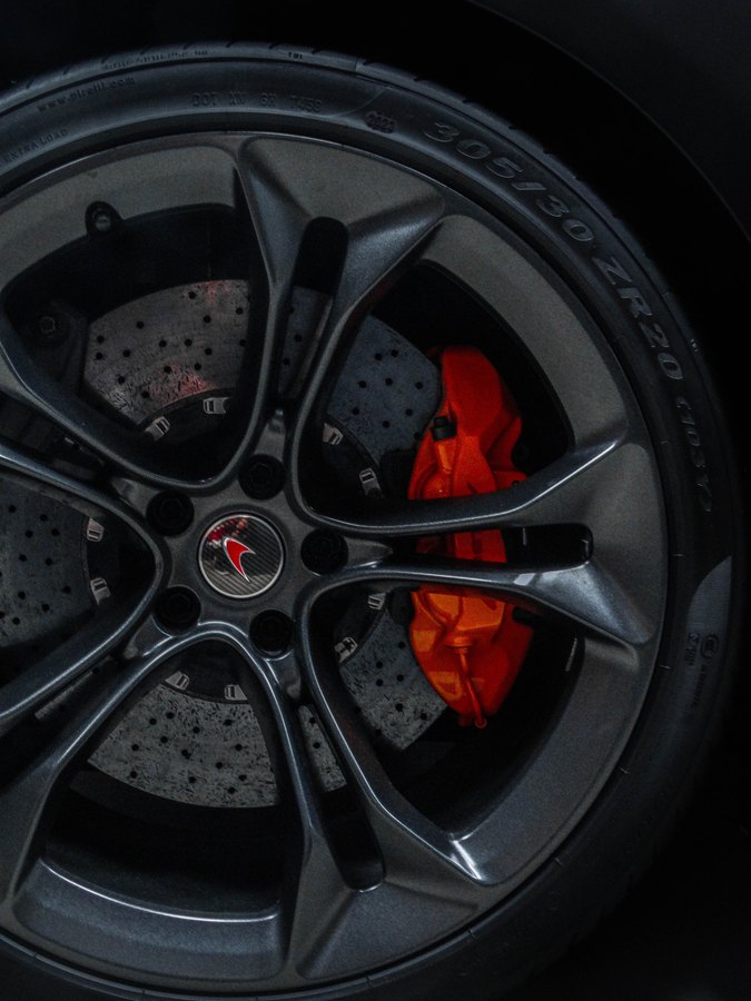 Red caliper behind gray twin-spoke wheel